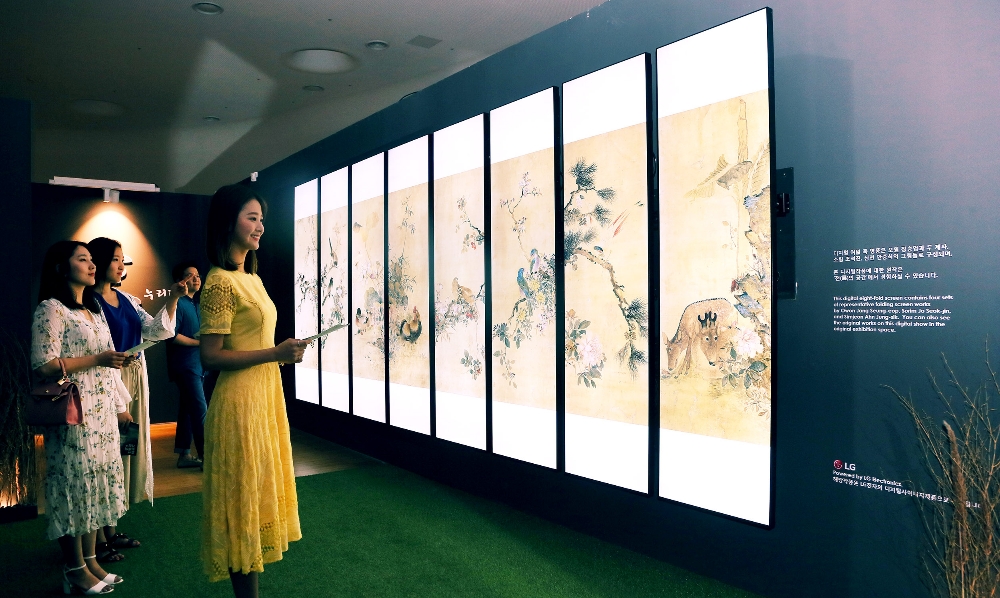△서울 중구 동대문 디자인 플라자(DDP)에서 ‘조선 최후의 거장, 장승업 X 취화선 展’을 찾은 관람객들이 LG 전자 울트라 스트레치 사이니지 8장으로 조성한 디지털병풍에서 장승업의 화조도를 감상하고 있다 / 사진=LG전자