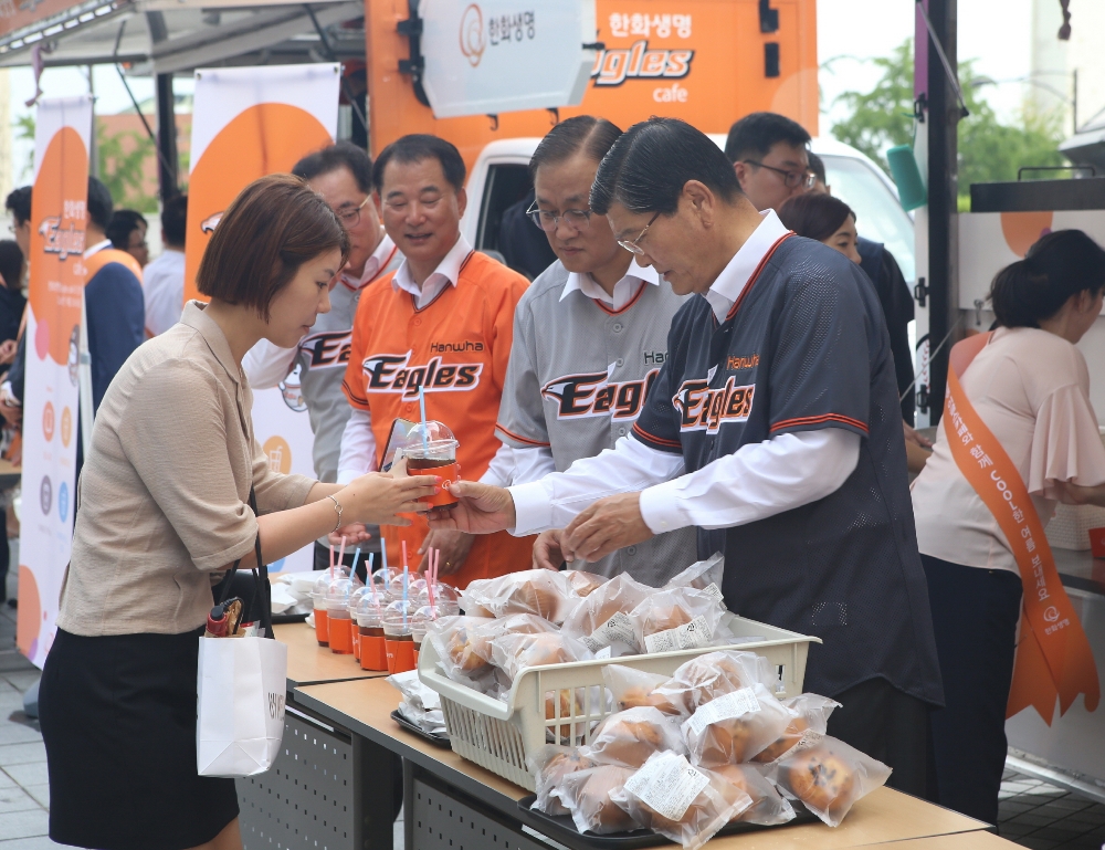△한화생명 차남규 부회장(우측)이 출근하는 임직원들에게 빵과 음료를 나눠주고 있다. / 사진=한화생명