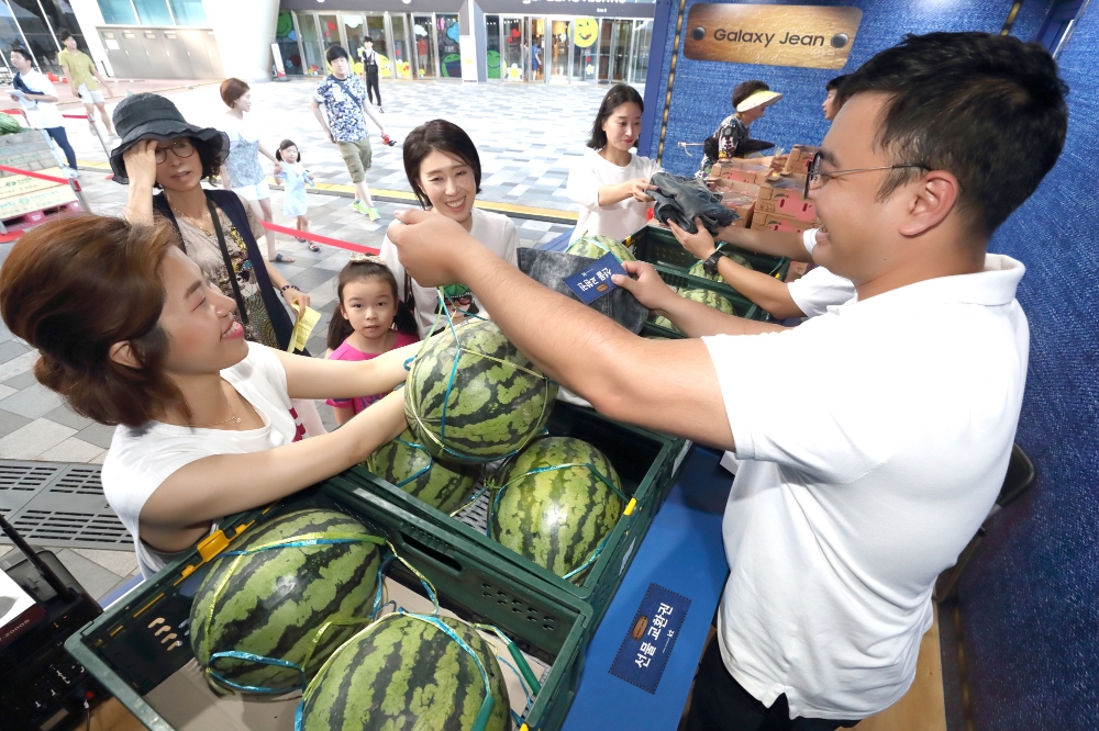 △KT는 지난 28일부터 이틀간 ‘갤럭시 진(Jean)’ 단독 출시를 기념하여, 서울 송파구 가든파이브 야외광장에서 기부공익사업재단 ‘아름다운가게’와 함께 청바지 기부행사를 진행했다. 사진은 청바지 등 의류 기부자에게 수박을 증정하는 모습.