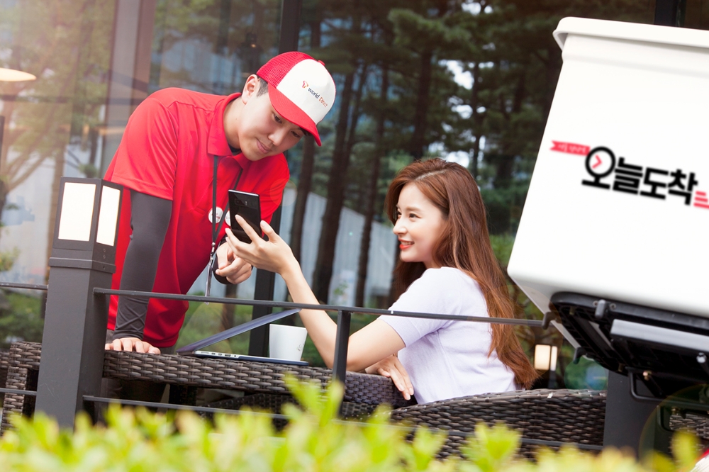 △SK텔레콤 ‘오늘도착’ 서비스 전문 배송기사가 고객(홍보모델)에게 휴대폰을 전달하며 상담하고 있는 모습. 고객이 ‘오늘도착’ 서비스를 신청하면, 전문 배송기사가 고객이 원하는 시간과 장소로 휴대폰을 무료로 배송해 준다