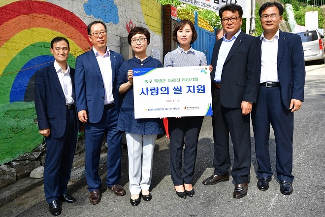 NH농협은행은 8월 한달간 취약계층 돌봄 활동을 집중 실시한다. 이재충 자금운용부문 트레이딩단장, 문영식 자금운용부문 외환파생센터장, 장미경 자금운용부문 부행장, 정수현 남대문 쪽방상담소장, 임정수 자금운용부문 자금부장, 강대진 자금운용부문 자금운용지원단장이 남대문 쪽방상담소 앞에서 돌봄 활동 기념 촬영을 하고 있다. / 사진 = NH농협은행