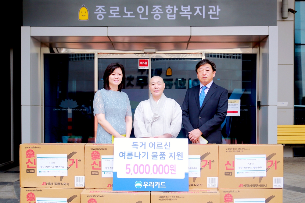 △(왼쪽부터) 김현미 독거노인종합지원 센터장, 종로노인종합복지관장 정관 스님, 이재용 우리카드 부장이 '독거 어르신 여름나기 물품 전달식' 후 기념촬영을 하고 있다./사진=우리카드