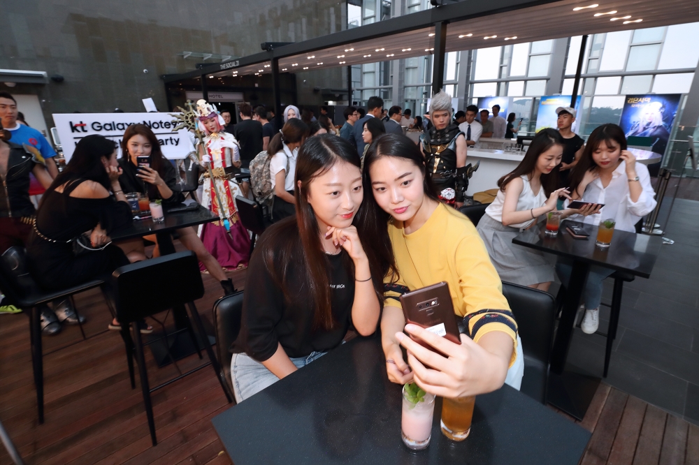△KT 갤럭시 노트9 사전개통 전야파티에 참석한 예약가입자가 갤럭시 노트9을 직접 체험해보고 있다