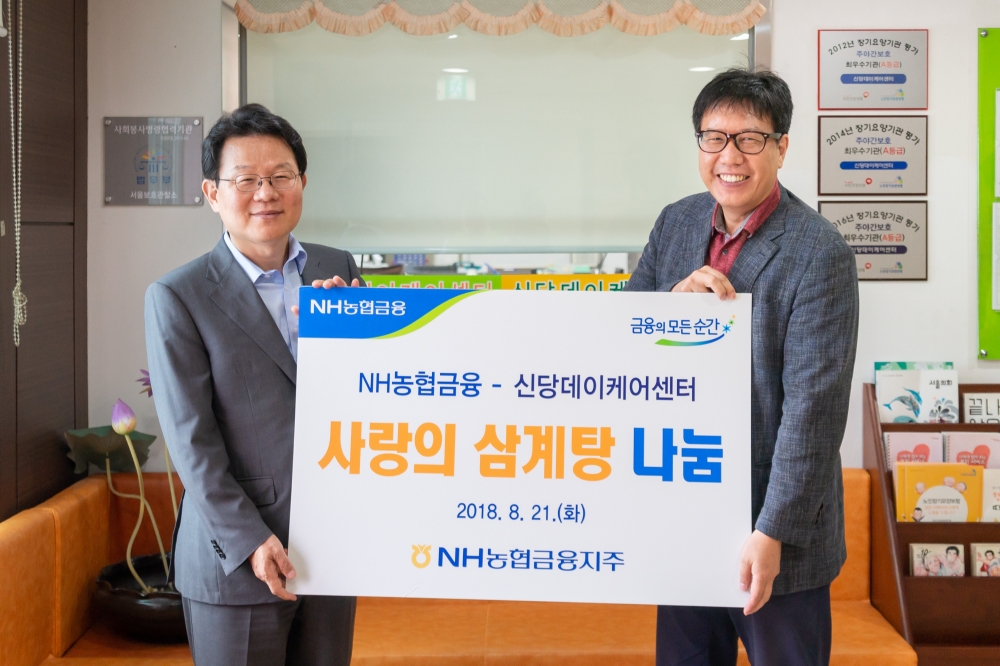 김광수 농협금융지주 회장(왼쪽) 이 21일 중구에 소재한 신당데이케어센터를 방문하여 관내 어르신에게 삼계탕을 전달하고 기념촬영을 하고 있다. / 사진= 농협금융지주