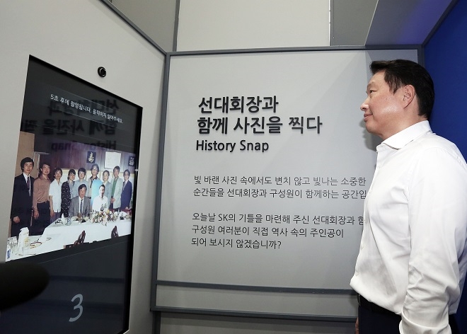 최태원 회장이 8월 14일 서울 종로구 서린동 SK사옥 로비에서 개막한 최종현 회장 20주기 사진전에서 아버지의 사진을 바라보고 있다. 출처 : SK그룹.