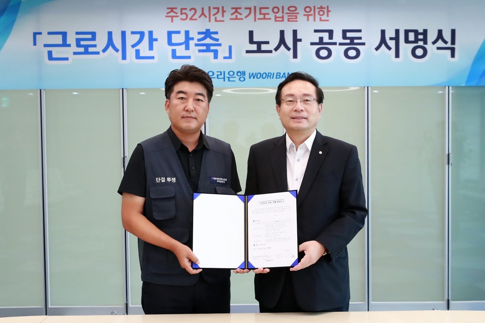 우리은행 노사는 오는 10월 주 52시간 근무제를 조기 도입하기로 30일 합의했다. 손태승 은행장(사진 오른쪽)과 박필준 노조위원장이 노사 공동 서명식 후 기념촬영을 하고 있다. / 사진= 우리은행