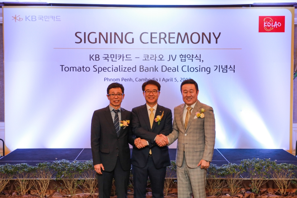 △4월 5일 캄보디아 프놈펜에서 열린 ‘토마토 특수은행(Tomato Specialized Bank)’ 인수 계약 마무리를 위한 ‘딜 클로징(Deal Closing)’ 행사 후 이동철 KB국민카드 사장(가운데)과 오세영 코라오그룹 회장(오른쪽), 정찬형 예금보험공사 이사(왼쪽)가 기념 촬영을 하고 있다./사진=KB국민카드