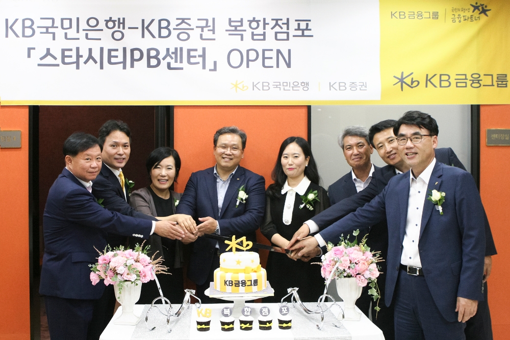 △17일 진행된 KB국민은행-KB증권 복합점포 개점행사에서 박정림 KB금융그룹 WM총괄 부사장(왼쪽 세번째), 정회철 KB국민은행 동부지역영업그룹 대표(오른쪽 세번째), 이홍구 KB증권 PB고객본부장(오른쪽 첫번째) 및 임직원들이 축하케이크를 자르고 있다. / 사진=KB금융지주