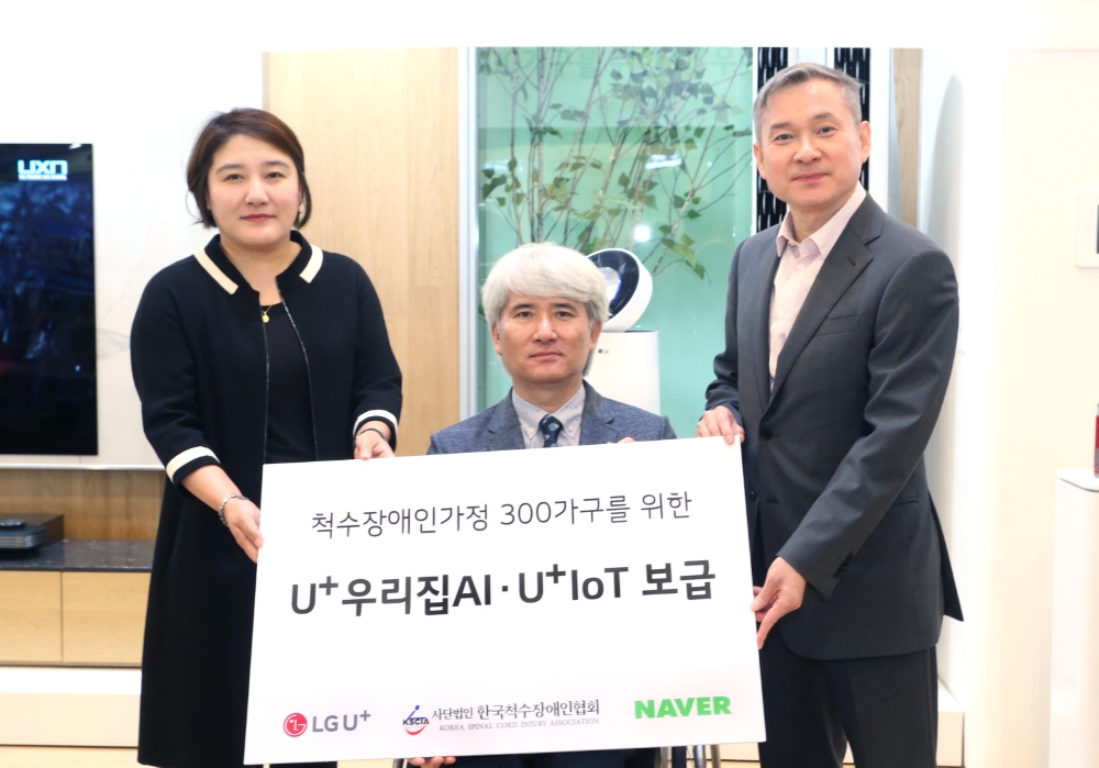 △오른쪽부터 하현회 LG유플러스 부회장, 이찬우 한국척수장애인협회 사무총장, 채선주 네이버 CCO가 U+우리집AI · U+IoT 보급 전달판을 들고 기념촬영하고 있는 모습
