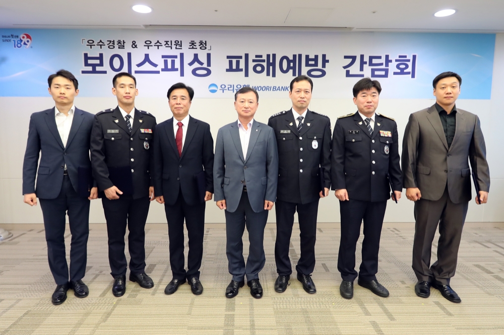 우리은행은 지난 2일 서울시 중구 본점에서 ‘보이스피싱 피해 예방 간담회’를 열고, 보이스피싱 피해를 막는데 도움을 준 경찰들에게 감사장과 기념품을 전달했다. 조수형 우리은행 소비자브랜드그룹 그룹장(사진 왼쪽 네번째)이 피해예방 유공 경찰관들과 기념촬영을 하고 있다. / 사진= 우리은행