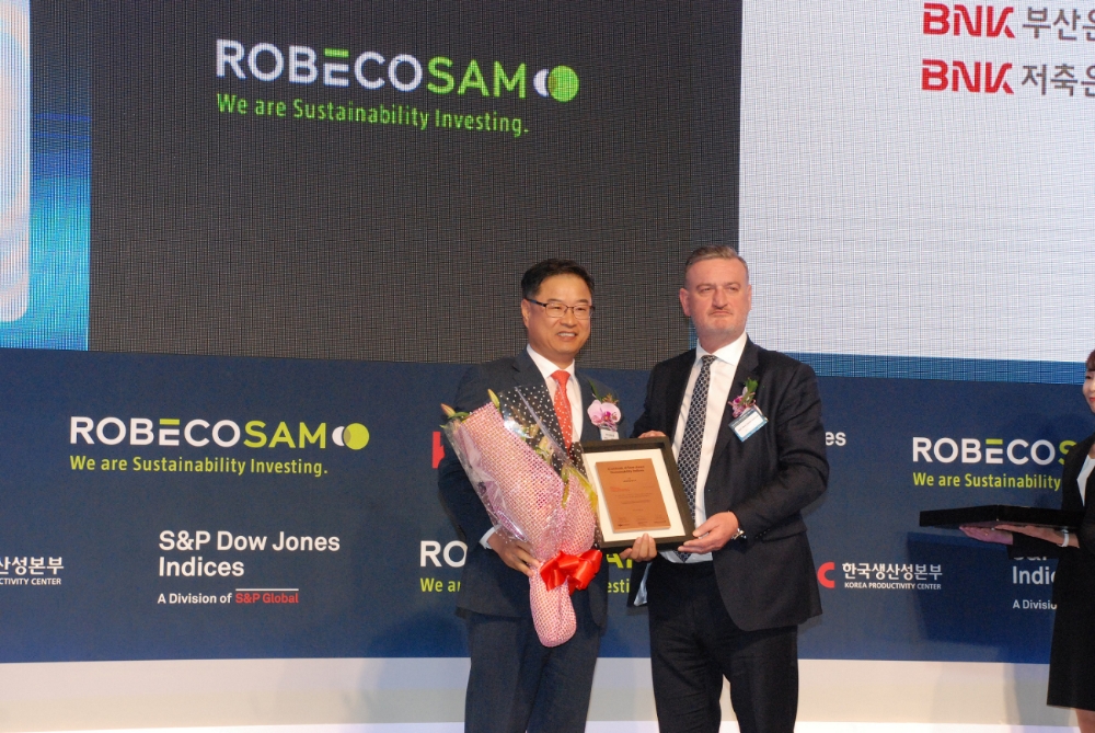 BNK금융그룹은 17일 그랜드 하얏트 서울 호텔에서 개최된 ‘2018 다우존스 지속가능경영지수 인증식’에서 4년 연속 ‘DJSI 아시아퍼시픽지수(Dow Jones Sustainability Index Asia-Pacific)’ 편입을 인증 받았다.사진 왼쪽부터 BNK부산은행 성경식 자금시장본부장, S&P 다우존스인덱스(S&P Dow Jones Indices) 존 데이비스(John Davies) 전무 이사 겸 글로벌 책임자. / 사진= BNK금융지주