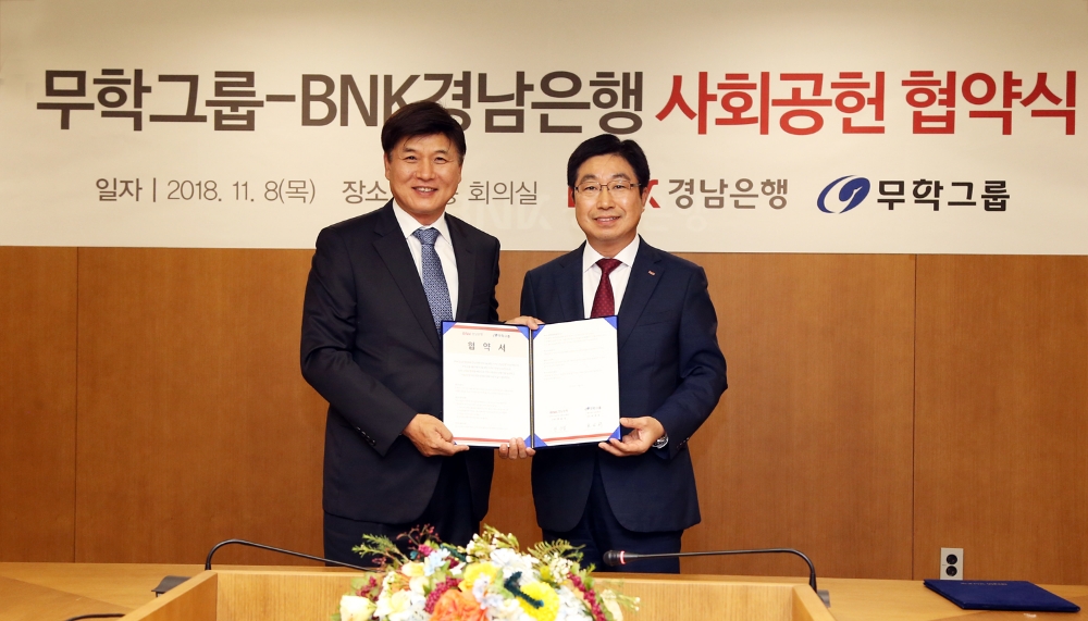 BNK경남은행 황윤철 은행장(사진 오른쪽)과 무학그룹 최재호 회장이 ‘사회공헌 협약’을 체결한 뒤 기념촬영하고 있다. / 사진= BNK경남은행