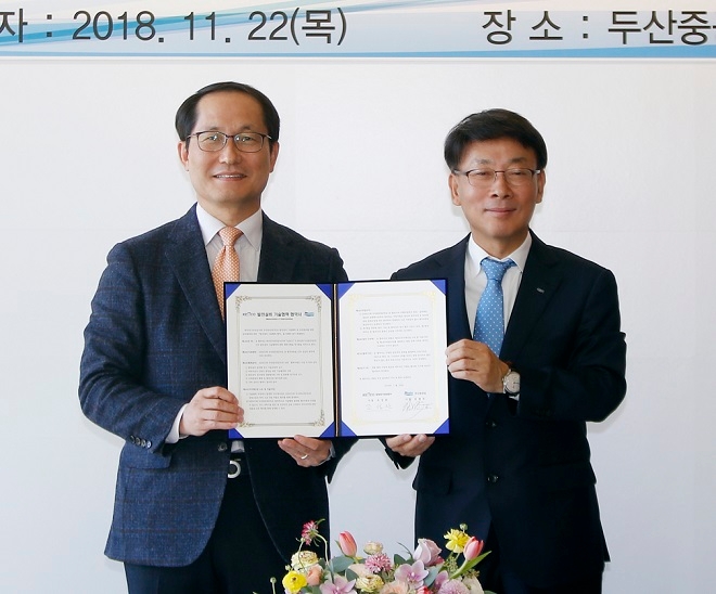 22일 경남 창원 두산중공업 게스트하우스에서 열린 ‘한국전기안전공사-두산중공업 발전설비 기술협력을 위한 업무협약식’에서 두산중공업 김명우 사장(오른쪽)과 한국전기안전공사 조성완 사장이 MOU를 체결한 후 협약서를 들고 기념촬영을 하고 있다. 출처=두산중공업.