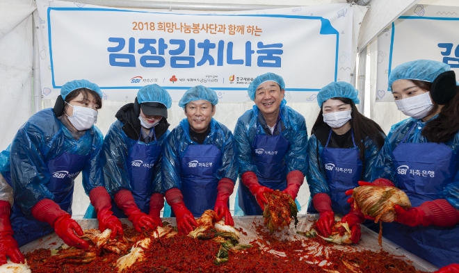 임진구 SBI저축은행 대표이사(오른쪽 세번째)와 정진문 대표이사(오른쪽 네번째), 희망봉사단원들이 소외 이웃들에게 전달할 김장김치를 만들고 있다. / 사진 = SBI저축은행