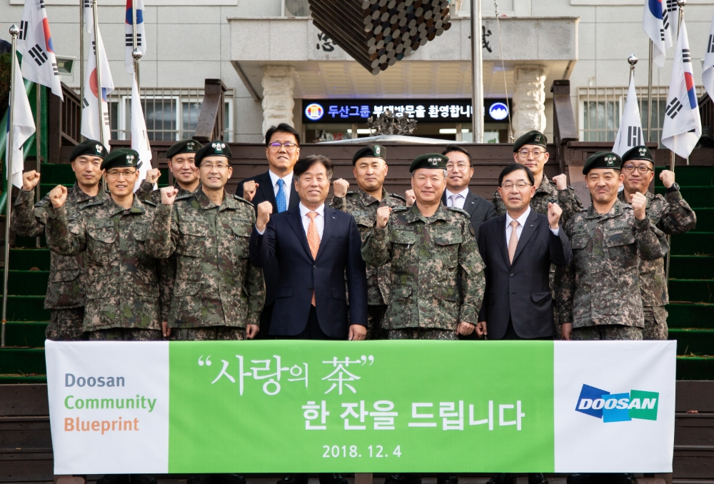 동현수 ㈜두산 부회장(앞줄 왼쪽에서 세 번째)과 임직원들이 강원도 양구 백두산 부대를 방문해 ‘사랑의 차’를 전달하고있다. 출처=두산그룹