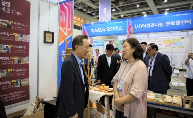 신용보증기금 윤대희 이사장이 7월 14일 대구 EXCO에서 열린 ‘2018 사회적경제 박람회’에서 사회적경제기업의 부스를 방문해 제품 설명과 경영 애로사항을 듣고 있다./사진=신용보증기금