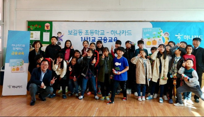 (왼쪽부터)최신자 하나카드 소비자보호부장, 육철민 소비자보호부 차장, 김형진 소비자보호부 수석(맨 오른쪽)과 금융교육 후 밝은 표정을 짓는 전라남도 완도군 보길도 소재 '보길동 초등학교' 학생들. / 사진 = 하나카드