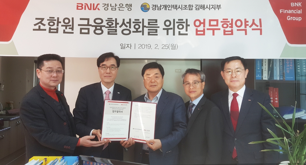 BNK경남은행 동부영업본부 예경탁 상무(사진 왼쪽 두번째)이 경남개인택시조합 김해시지부 김두식 지부장(사진 왼쪽 세번째)과 ‘금융 지원 업무 협약’을 맺고 있다./사진=BNK경남은행