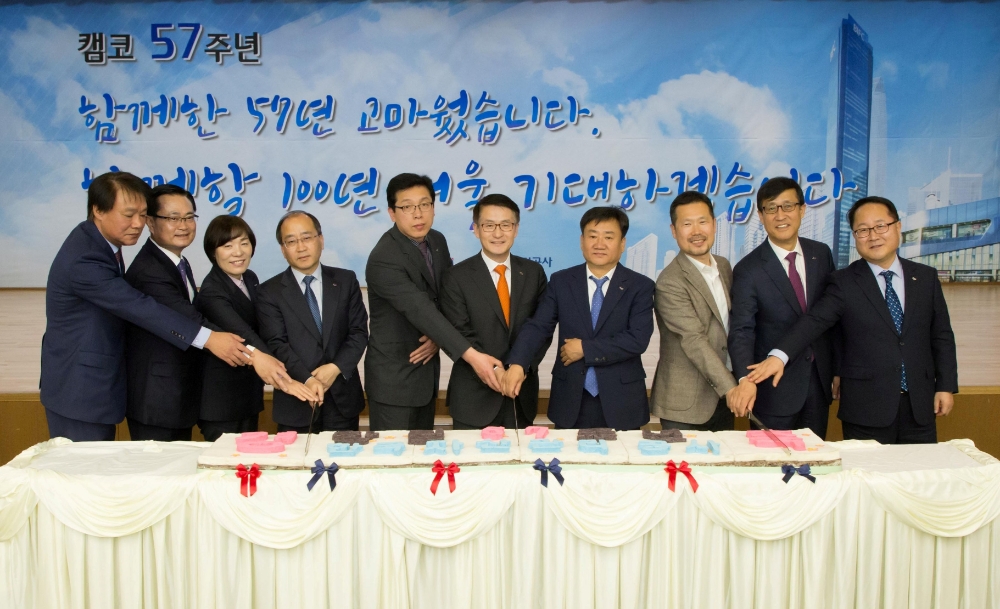 문창용 캠코(한국자산관리공사) 사장(왼쪽에서 여섯번째)이 4월 3일(수) 부산국제금융센터(BIFC)에서 개최된 ‘한국자산관리공사 제57회 창립기념식’에서 김상형 노동조합위원장(오른쪽에서 세번째), 장기근속직원 등과 함께 기념떡 커팅식을 하고 있다./사진=캠코