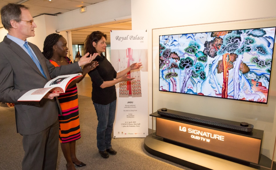 △파리 유네스코본부 전시장에서 관람객들이 올레드 TV에 보이는 궁중자수 작품을 관람하고 있다/사진=LG전자