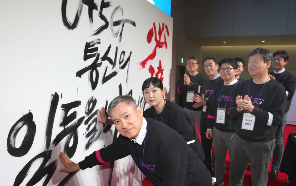 △하현회 LG유플러스 부회장이 지역 대리점 대표 점장들과 5G 붓드로잉 퍼포먼스 작품에 손도장을 찍고 있다/사진=LG유플러스