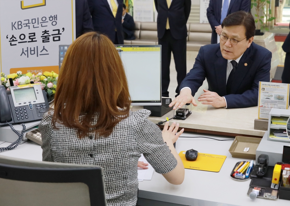 12일 KB국민은행 여의도 본점에서 열린 '손으로 출금 서비스' 출시 기념식에서 최종구 금융위원장이 서비스 시연을 하고 있다. / 사진= KB국민은행
