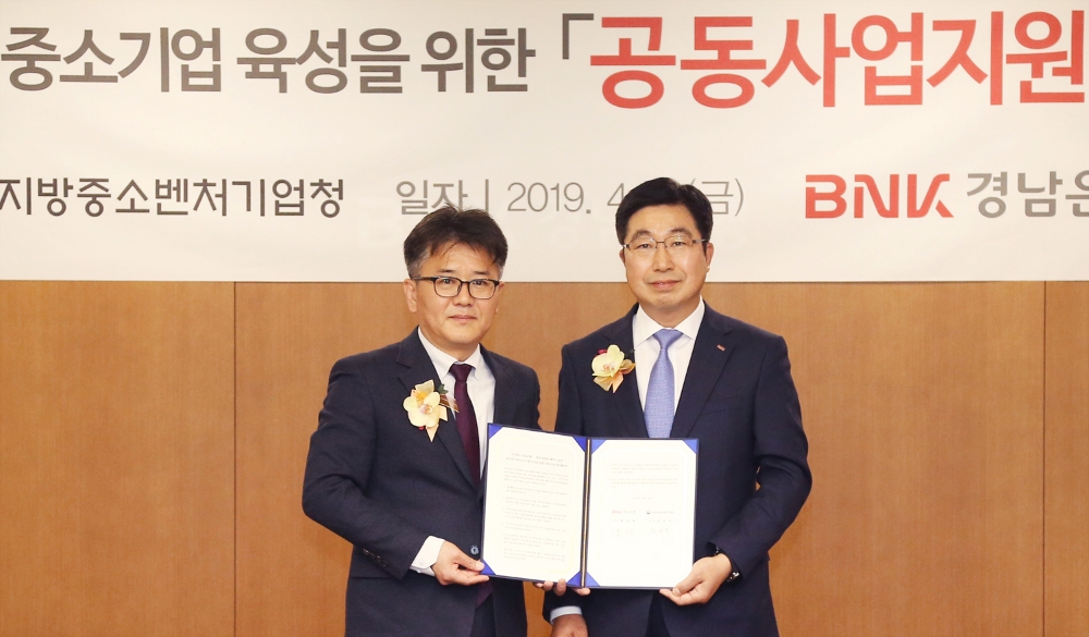 황윤철 BNK경남은행장(사진 오른쪽)과 경남지방중소벤처기업청 권영학 청장이 2019년 지역 중소기업 육성을 위한 공동사업지원 협약을 체결하고 있다./사진=BNK경남은행