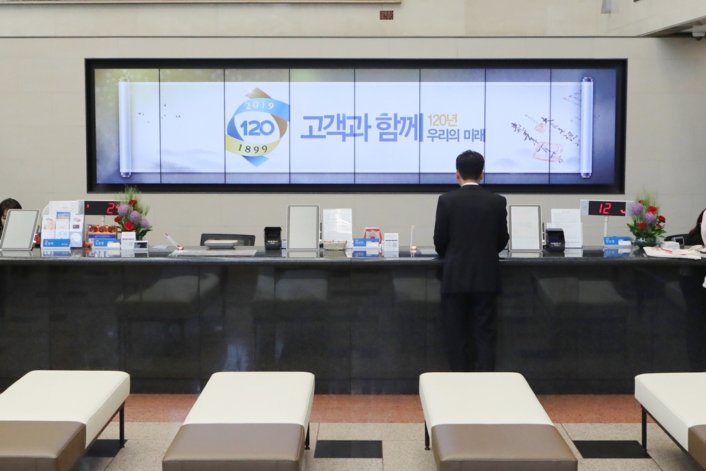 고객들이 디지털사이니지가 설치된 우리은행 본점영업부에서 업무를 처리하고 있다./사진=우리은행