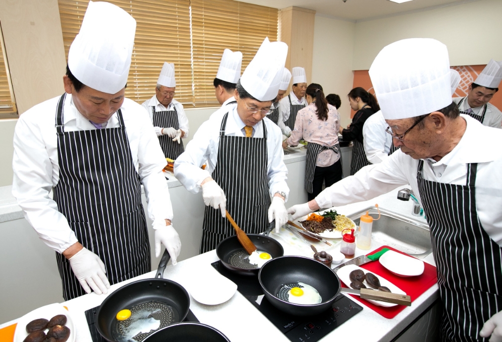 △24일(금) 충북 옥천군 노인〮장애인복지관에 개소한 ‘생명숲 100세 힐링센터’에서 (왼쪽부터) 김재종 옥천군수와 이종서 생명보험재단 이사장이 어르신과 함께 요리교실 프로그램에 참여하고 있다. / 사진=생명보험재단