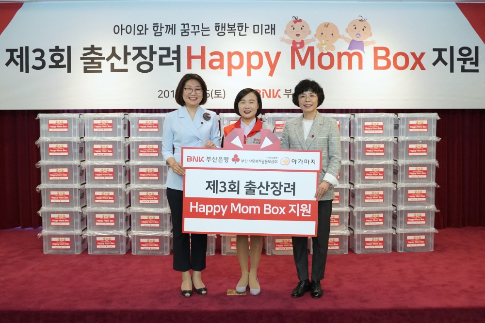 (왼쪽부터) 부산사회복지공동모금회 장보임 사무처장, BNK부산은행 박경희 동부영업본부장, 부산돌봄사회서비스센터 안혜경 센터장이 해피맘 박스 전달 후 기념촬영을 하고 있다./사진=부산은행
