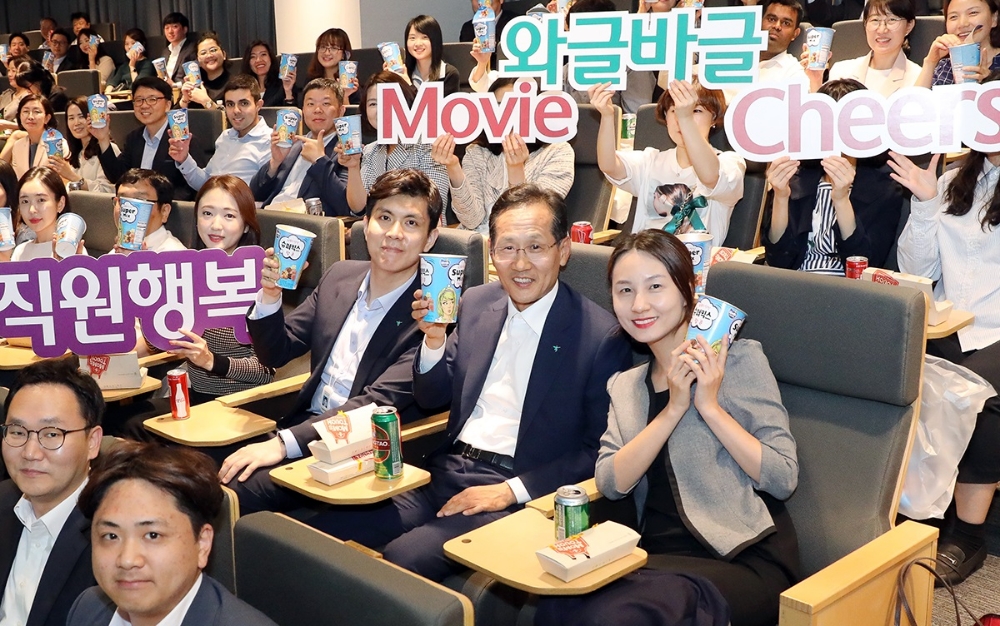 KEB하나은행은 28일 저녁 을지로 신축본점 대강당에서 직원들의 행복과 소통을 위한 시네마 데이 행사 '와글바글 무비 치어스'를 개최했다. 이날 깜짝 방문해 직원들과 영화를 함께 보며 격의 없이 소통하는 시간을 가진 지성규 KEB하나은행장(사진 앞에서 두번째 줄 오른쪽에서 두번째)이 직원들과 함께 팝콘을 들고 기념촬영을 하고 있다. / 사진= KEB하나은행