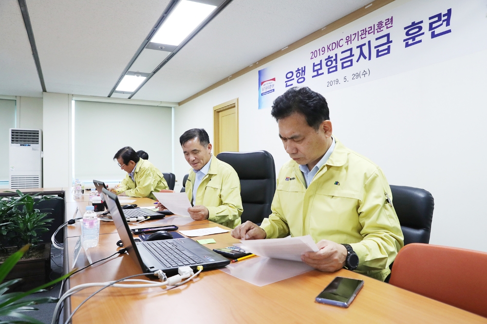 29일 실시한 예금 대지급 훈련에서 위성백 사장(오른쪽 두번째)이 가상의 예금자가 되어 금융기관 부실발생시 예금보호가 가능한 예금을 계산하고 청구하는 모의 훈련을 실시하고 있다./사진=예금보험공사