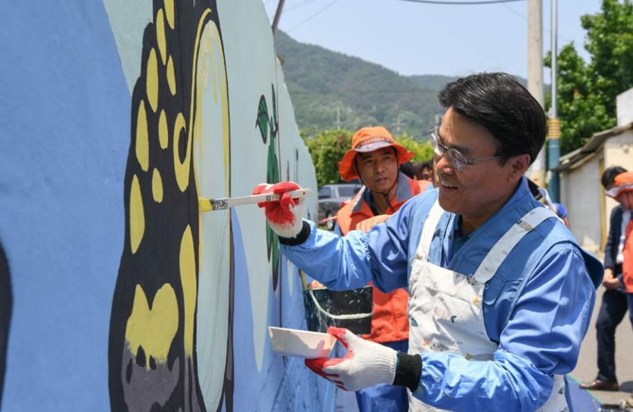 △최정우 포스코 회장이 광양제철소 인근 마을에서 벽화 그리기 봉사에 참여하고 있다/사진=오승혁 기자(자료 편집)