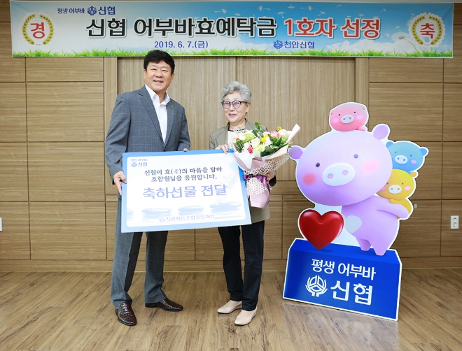 7일 충남 천안신협에서 열린 ‘어부바효예탁금 1호 가입자 축하행사’에서 김윤식(왼쪽) 신협중앙회장이 1호 가입자의 어머니에게 선물을 전달하고 있다. / 사진 = 신협중앙회