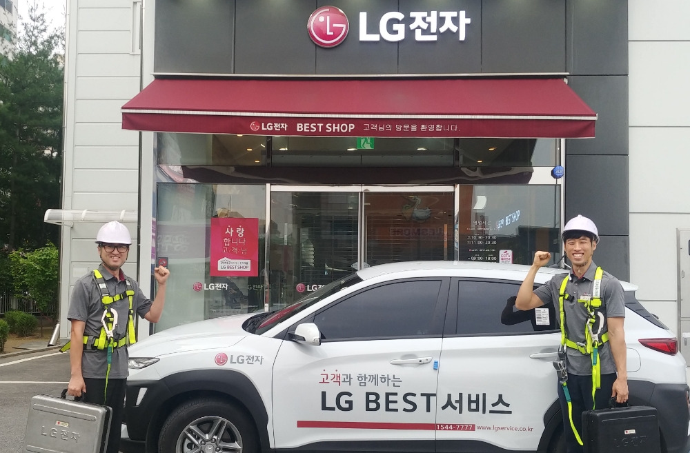 △ LG전자 서비스 엔지니어가 에어컨 실외기 등을 수리시 사용하는 보호구를 착용하고 신규 공급차량 앞에서 포즈를 취하고 있다/사진=LG전자