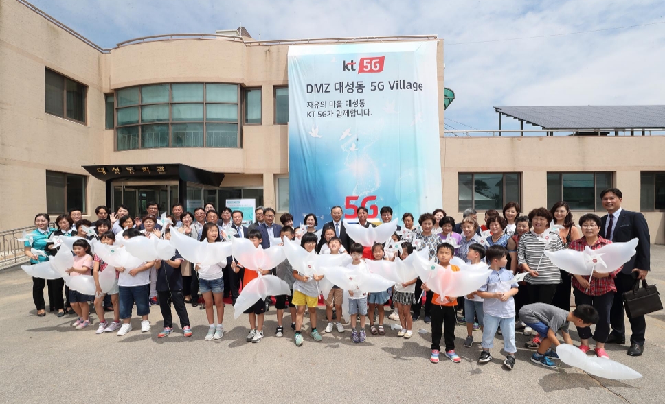 △황창규 KT 회장을 비롯한 KT임직원, 대성동마을 주민과 학생들이 기념촬영을 하고 있다/사진=KT