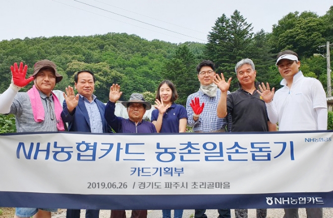 지난 26일 NH농협카드 관계자와 마을 주민들이 농촌일손돕기 행사를 마치고 기념촬영을 하고 있다. / 사진 = NH농협카드