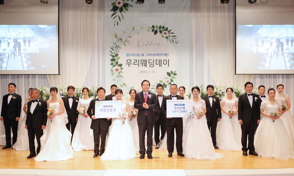 손태승(가운데) 우리다문화장학재단 이사장이 10쌍의 다문화 부부와 기념촬영을 하고 있다./사진=우리금융그룹