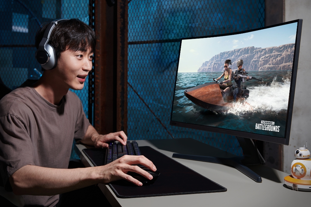 △삼성전자 모델이 지싱크 호환 커브드 모니터로 배틀그라운드 게임을 즐기는 모습을 연기하고 있다/사진=삼성전자