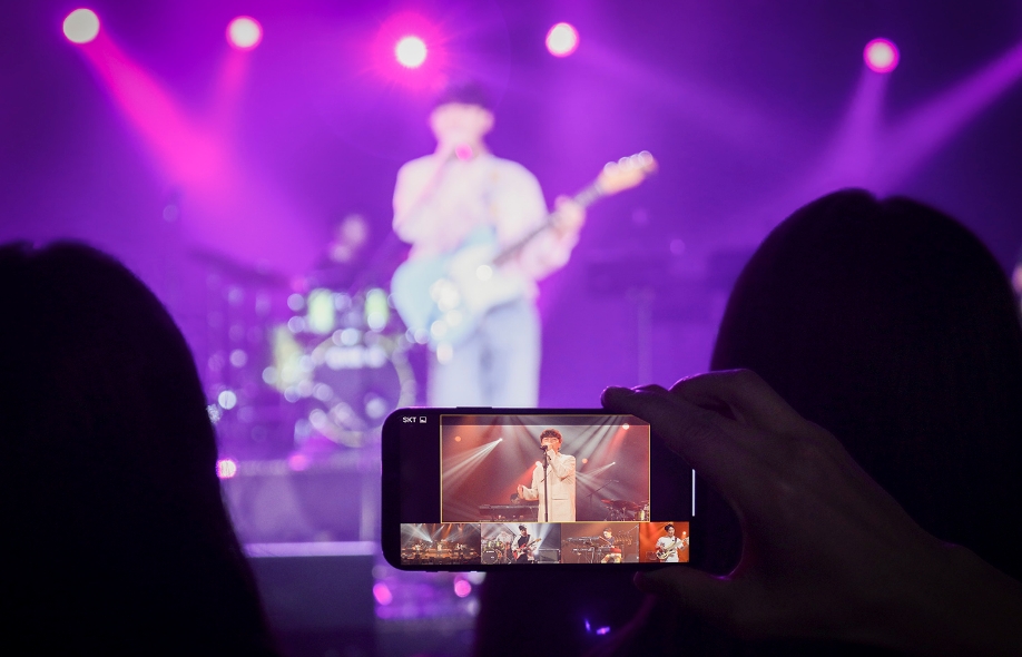 △SK텔레콤 5G 음악서비스 뮤직 멀티뷰를 통해 밴드의 공연 중 원하는 내용만 선택하여 보고 있는 고객 모습의 시연/사진=SK텔레콤
