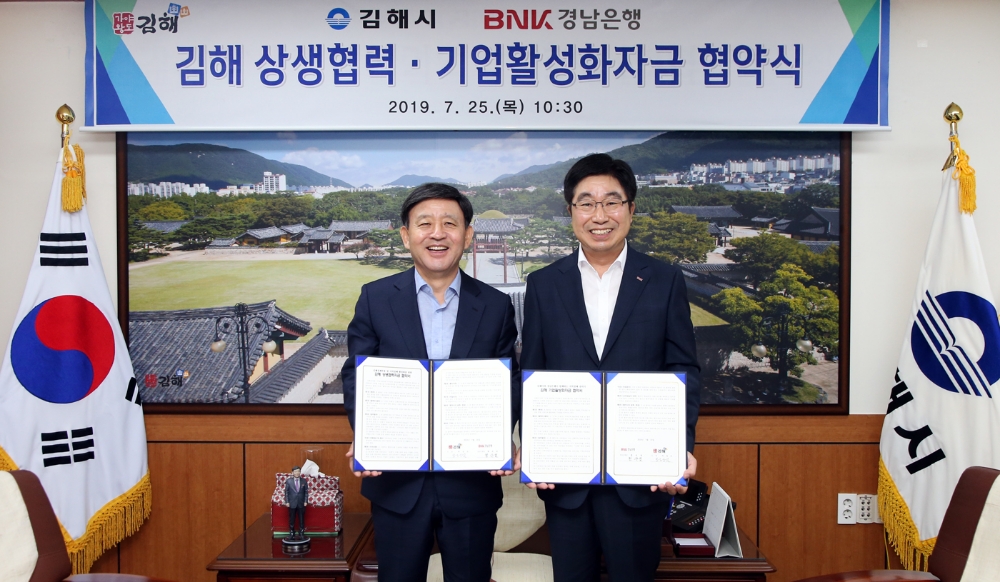 BNK경남은행 황윤철 은행장(사진 오른쪽)이 김해시 허성곤 시장과 상생협력자금 업무 협약과 기업활성화자금 업무 협약을 동시 체결한 뒤 기념촬영하고 있다./사진=경남은행