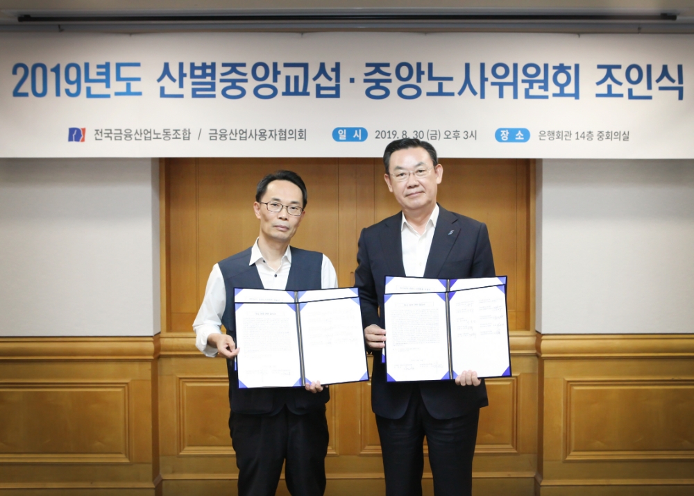 김태영 금융산업사용자협의회 회장(은행연합회장)(오른쪽)과 허권 금융산업노동조합 위원장(왼쪽)이 30일 개최된 제5차 산별교섭회의에서 2019년도 임금협약을 체결한 후 기념촬영을 하고 있다. / 사진= 금융산업사용자협의회