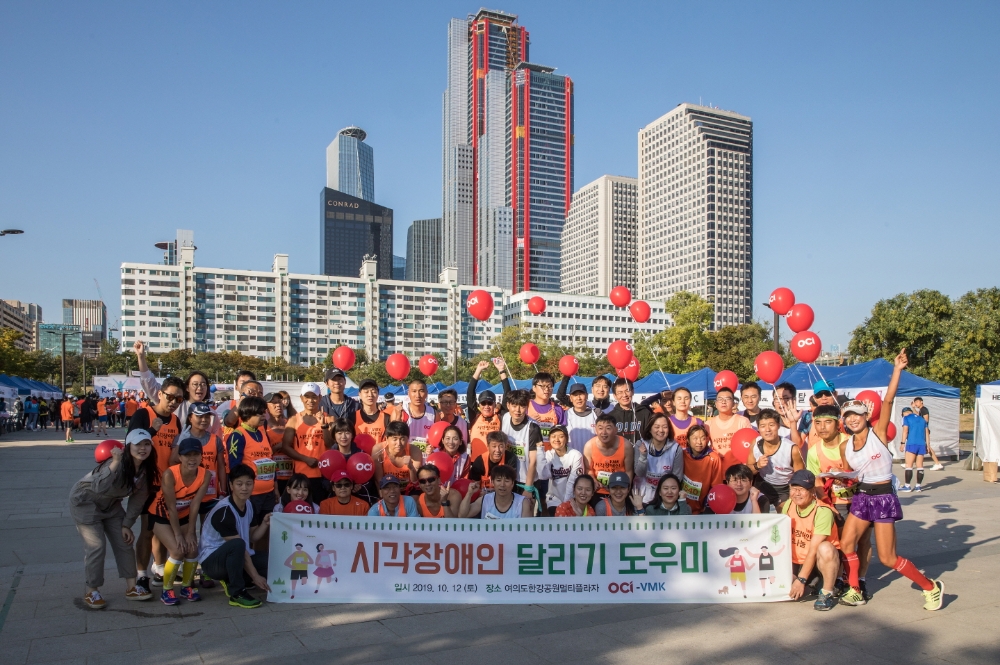 △OCI 임직원들의 시각장애인 마라톤 대회 도우미 참가 모습/서진=OCI