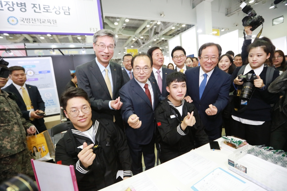허인 KB국민은행장(가운데 왼쪽)과 오거돈 부산시장(오른쪽)이 17일 부산 벡스코에서 열린 '2019 KB굿잡 부산 잡 페스티벌' 내 국방전직교육원에서 취업을 준비하는 장병들과 기념촬영을 하고 있다. / 사진= KB국민은행