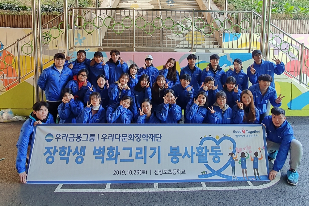 우리금융그룹 우리다문화장학재단 대학생 40여명이 서울 신상도초등학교에서 벽화그리기 봉사활동 후 기념촬영을 하고 있다./사진=우리금융그룹