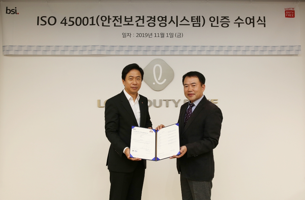 롯데면세점이 업계 최초로 국내 전 사업장의 ‘국제 안전보건경영시스템(ISO 45001)’ 인증을 획득했다. 지난 1일 이갑 롯데면세점 대표(왼쪽)와 송경수 BSI Korea 총괄책임대표(오른쪽)이 수여식에서 기념촬영을 하고 있다. /사진제공=롯데면세점
