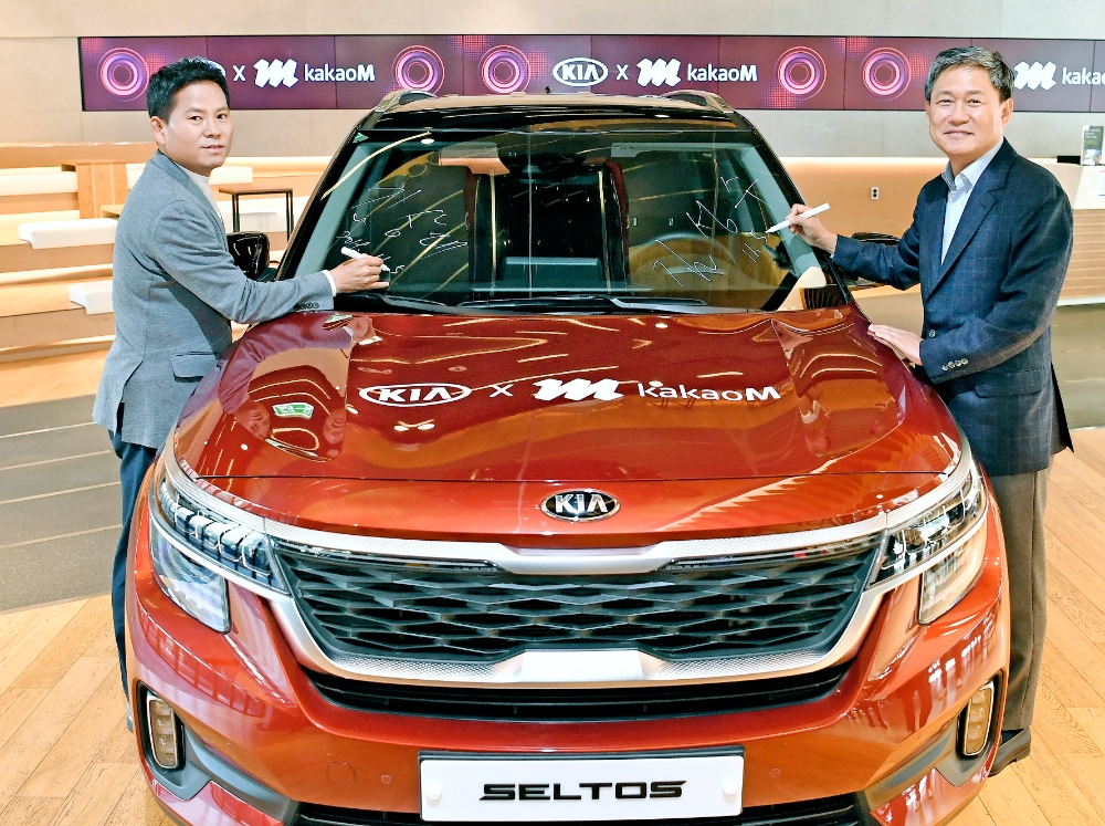 △5일 BEAT360에서 진행된 기아차-카카오 M 파트너십 체결식에서 (왼쪽부터) 김상대 기아차 고객경험본부장과 김성수 카카오 M 대표이사가 하이클래스 소형 SUV 셀토스에 기념 서명을 하고 있는 모습/사진=기아차