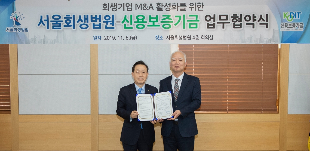 윤대희 신용보증기금 이사장(왼쪽)이 정형식 서울회생법원장(오른쪽)과 함께 8일 서울회생법원에서 열린 '회생기업 M&A 활성화를 위한 업무협약'에서 기념촬영을 하고 있다./사진=신용보증기금