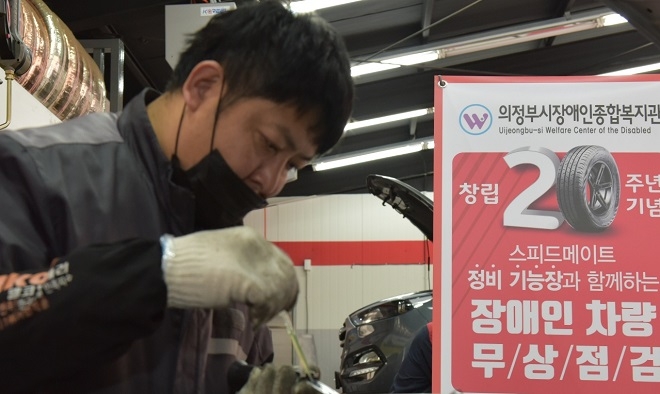 SK네트웍스 스피드메이트 정비 전문가가 10일 의정부 신시가지점에서 지역 장애인 차량 36대를 대상으로 무상점검 행사를 가졌다. (사진=SK네트웍스)