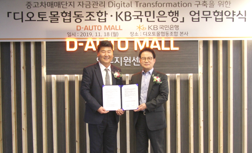 11월 18일 대전시 유성구 디오토몰 자동차복합매매단지에서 열린 '중고차 매매단지 자금관리 디지털 트랜스포메이션 구축을 위한 업무협약식'에서 참석자들이 기념촬영을 하고 있다. (왼쪽부터) 백승호 디오토몰협동조합 이사장, 신덕순 KB국민은행 중소기업고객그룹 대표. / 사진= KB국민은행